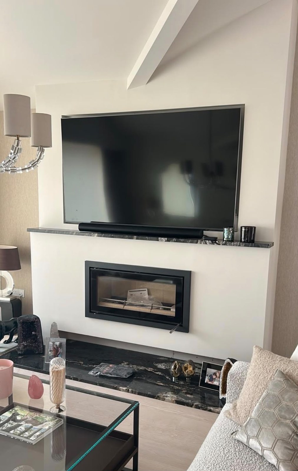 Sleek inset wood burner set into a white chimney breast beneath a marble shelf