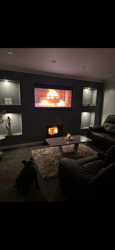 Evening shot of a lit wood burner warming a family living room