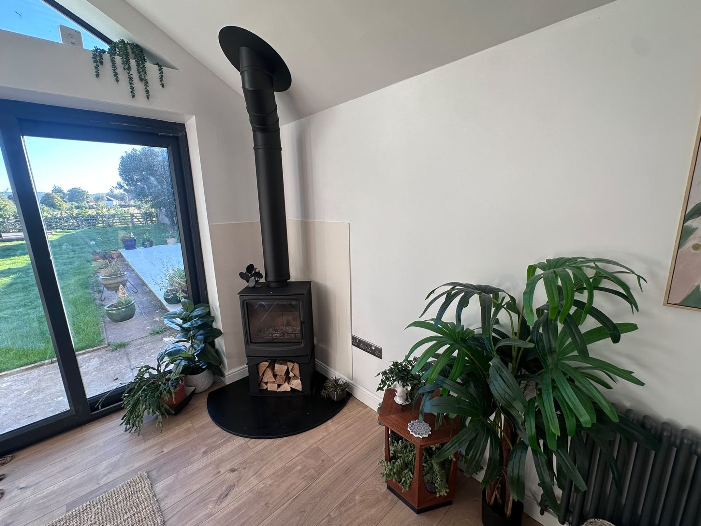 Corner wood burner with garden view and house plants